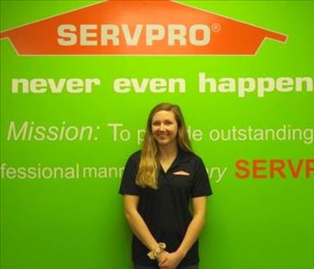 Brittany Paff standing in front of a green wall with the SERVPRO logo and mission statement below it.